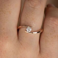 a woman's hand with a diamond ring on top of her finger, showing the band