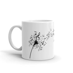 a white coffee mug with music notes and a dandelion design on the side