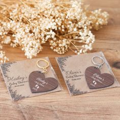 two wooden heart shaped keychains sitting on top of a table next to flowers