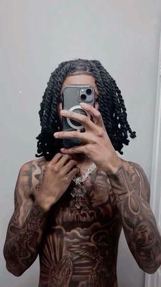 a man with dreadlocks taking a selfie in front of a mirror while holding a camera