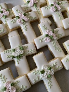 decorated cookies arranged in the shape of crosses with flowers on them are ready to be eaten