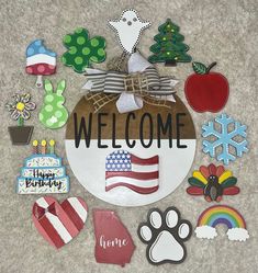 a welcome sign surrounded by cut out magnets and other items on the floor in front of a carpeted area