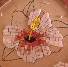 a flower made out of mosaic tiles on the floor