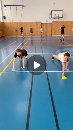 several people are doing push ups on a gym floor