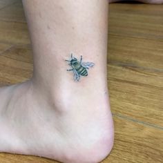 a small bee tattoo on the ankle