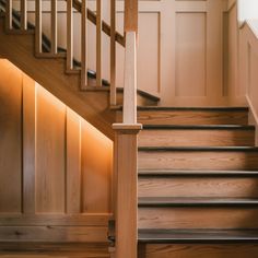 a wooden stair case next to a set of stairs