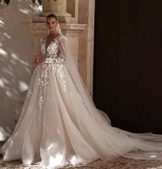 a woman in a wedding dress standing next to a wall