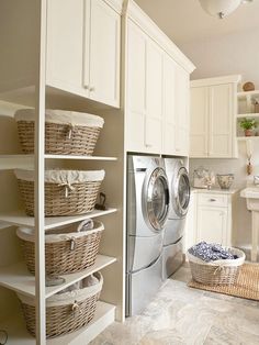 a washer and dryer sitting in a room next to some shelves with baskets on them