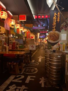 the inside of a chinese restaurant with lots of food on tables and signs hanging from the ceiling