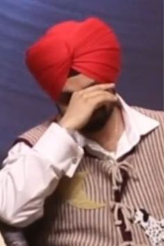 a man with a red turban covering his face