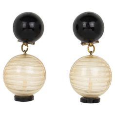 pair of black and white earrings with wooden balls on each earring, isolated against a white background