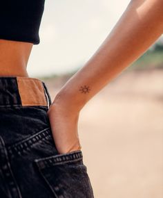 a woman's arm with a small star tattoo on it