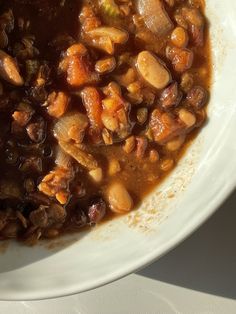 a white bowl filled with beans and meat