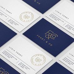 several business cards with gold foil on them, all in navy blue and white colors