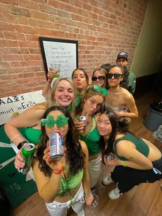 a group of young women standing next to each other in front of a brick wall