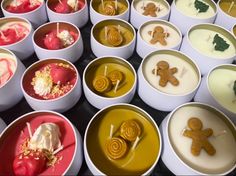 several bowls filled with different types of desserts and candies on display in them