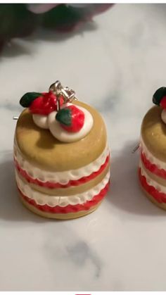 two small cakes decorated with christmas decorations on top of a white countertop next to each other