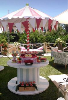 a table that has some food on top of it in the grass with umbrellas