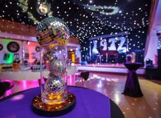 a disco ball on top of a table in a room filled with lights and decorations