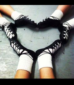 two people in black and white socks making a heart shape with their hands on the floor