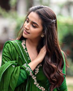 a woman with long hair wearing a green dress