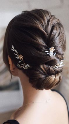 a woman wearing a hair comb with flowers on it's head and braid in her hair