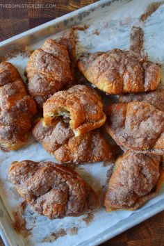 several pastries sitting on top of a baking pan covered in powdered sugar and cinnamon