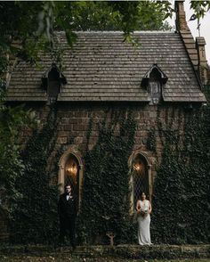 a bride and groom standing in front of an old brick building with ivy growing on it