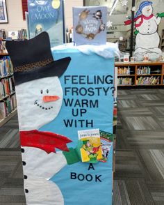 a book display with a snowman wearing a hat and scarf