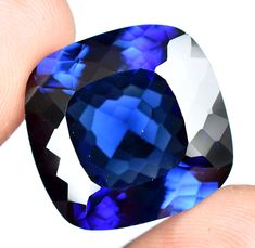 a large blue diamond being held in someone's hand with it's finger