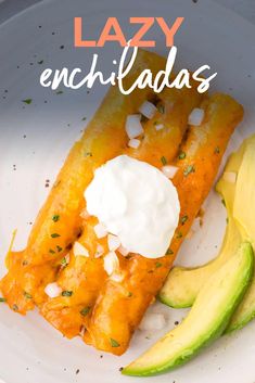 a white plate topped with an enchiladas covered in sour cream and avocado