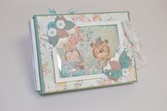 an altered photo frame with flowers and cats on the front is sitting on a table