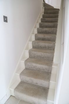 a set of stairs leading up to the top floor in a house with white walls