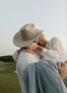 two women hugging each other in the middle of a field