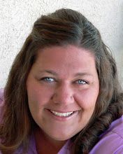 a woman with long brown hair smiling at the camera and wearing a purple sweater over her shoulders