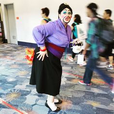 a man dressed as a clown standing in front of a group of people wearing costumes