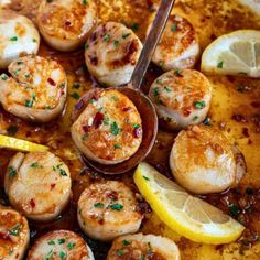 a pan filled with cooked scallops and lemon wedges