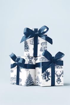 three presents wrapped in blue and white wrapping paper with bows on them, sitting next to each other