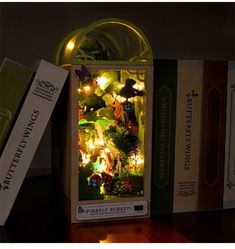 an illuminated christmas tree in a box on a table