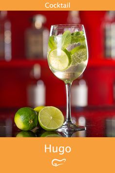 a glass filled with water and limes on top of a table