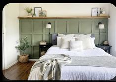 a large bed sitting in a bedroom next to a wooden shelf with pictures on it