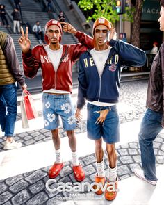 three men are standing in front of some steps and one is holding his hand up