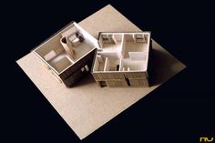 two model houses sitting on top of a piece of paper with the floor cut out