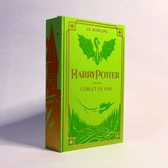 a green harry potter book sitting on top of a table