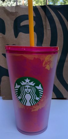 a pink starbucks cup with a yellow straw in it