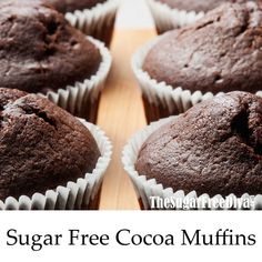 there are chocolate muffins in the paper wrappers on this wooden tray with text that reads sugar free cocoa muffins