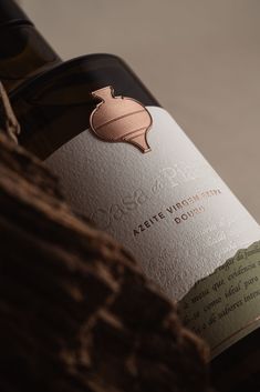 a bottle of wine sitting on top of a wooden table next to a piece of wood