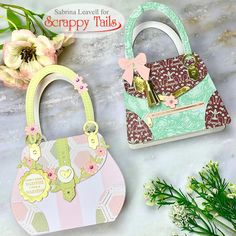 two purses sitting next to each other on a table with flowers in the background