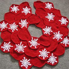 red and white crocheted snowflakes arranged in a circle on the floor