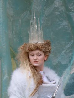 a woman with long blonde hair wearing a white fur coat